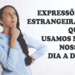 Expressões estrangeiras que usamos no nosso dia a dia (Na Imagem tem uma mulher branca, com o cabelo preto preso em uma trança de lado, a mesma esta de blusa azul com a mão no queixo pensativa. Ao lado dela em letras grandes e pretas tem a frase inicial).